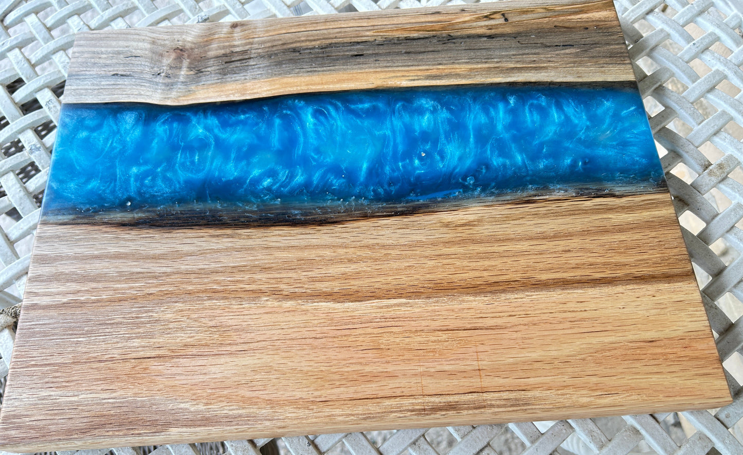 Wooden cutting board with blue resin inlay