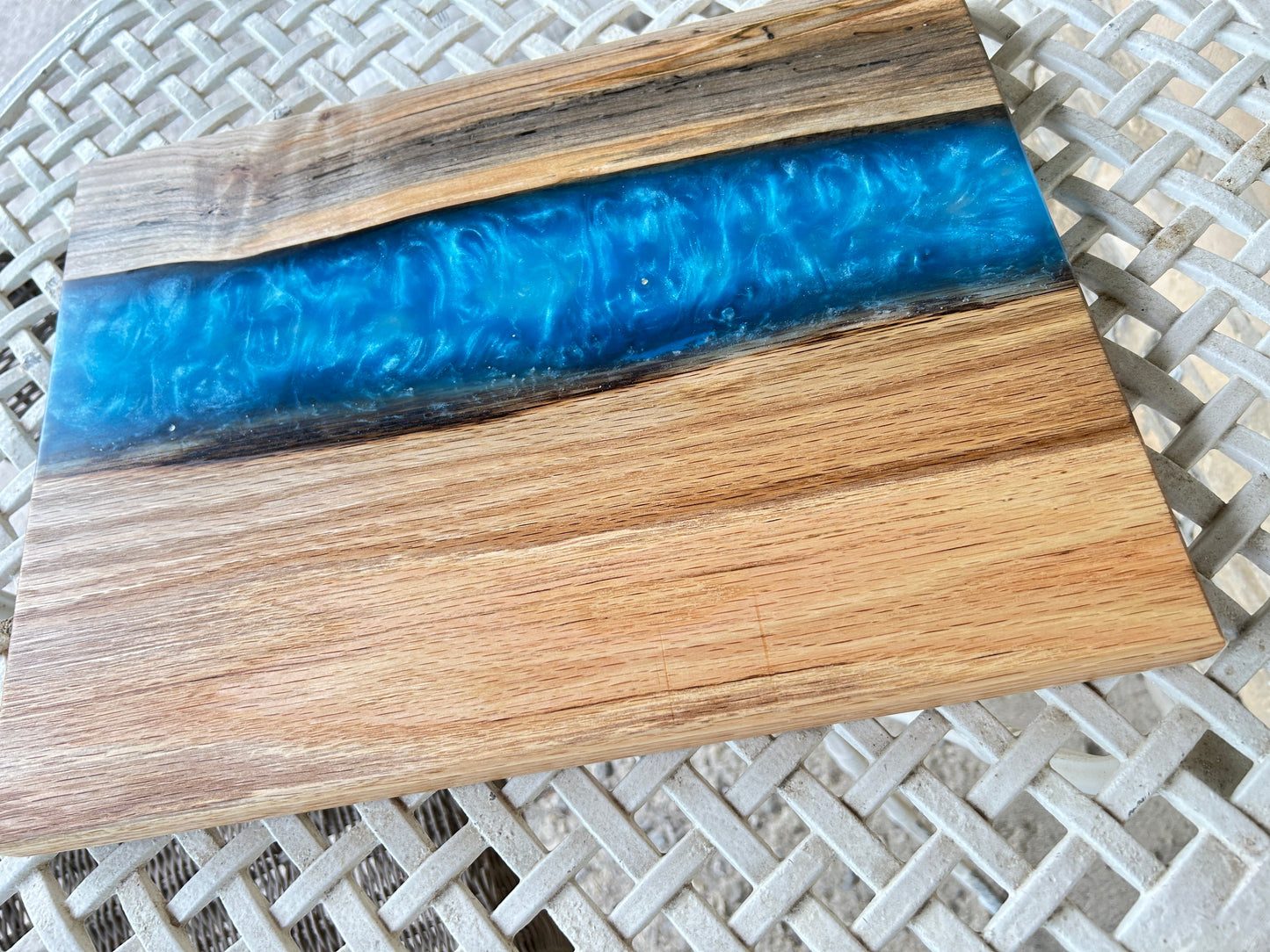 Wooden cutting board with blue resin inlay