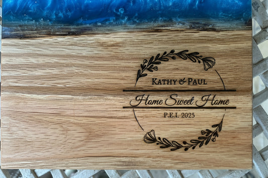 Wooden cutting board with engraved text and design, placed on a textured surface.