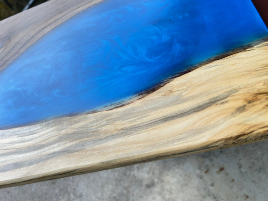 Close-up of a wooden surface with blue resin inlay
