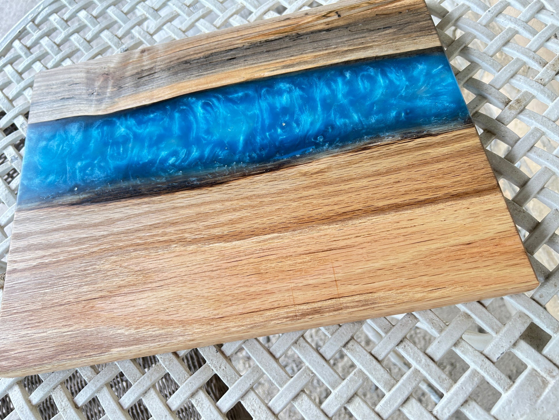 Wooden cutting board with blue resin inlay