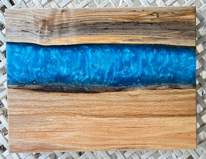 Wooden cutting board with blue resin