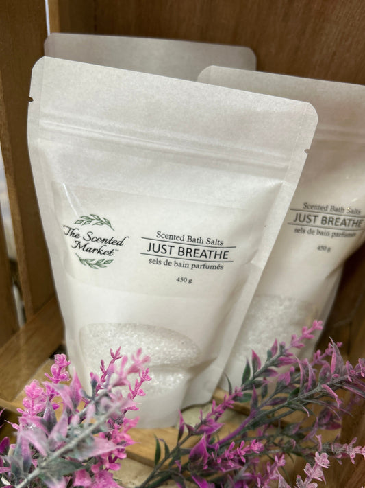 Scented bath salts packaging with lavender flowers on a wooden shelf