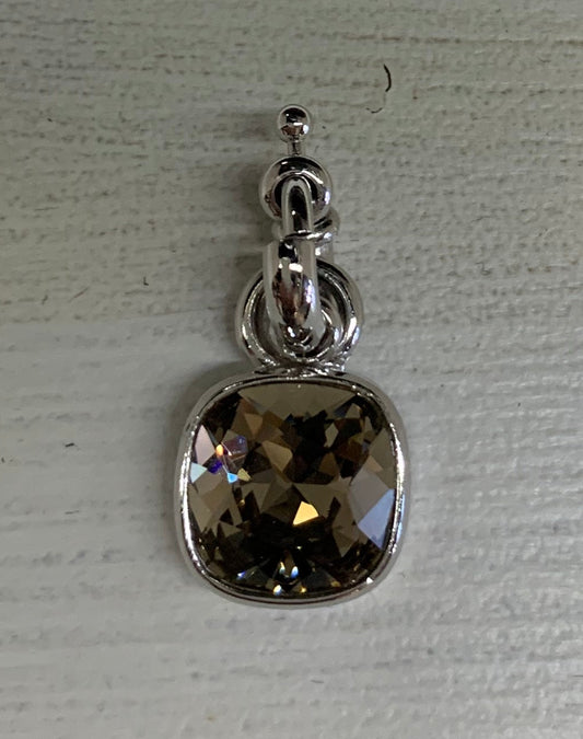 Silver earring with a gemstone on a textured white surface