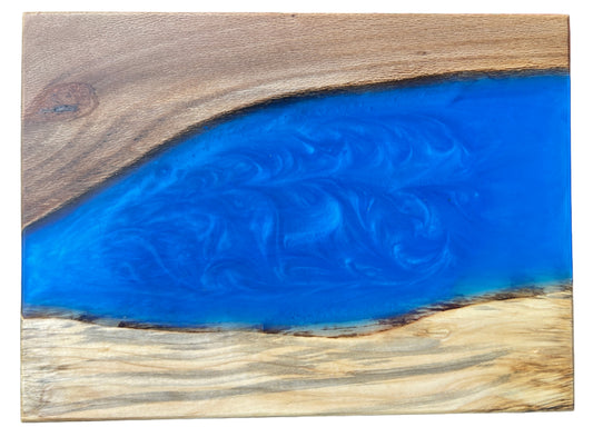 Wooden board with a blue resin finish on a concrete surface