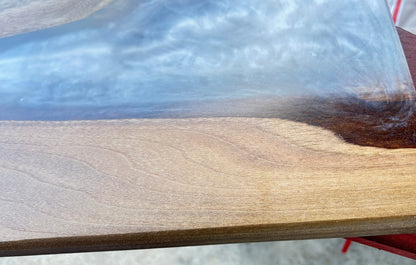 Wooden surface with a clear resin finish on a blurred outdoor background